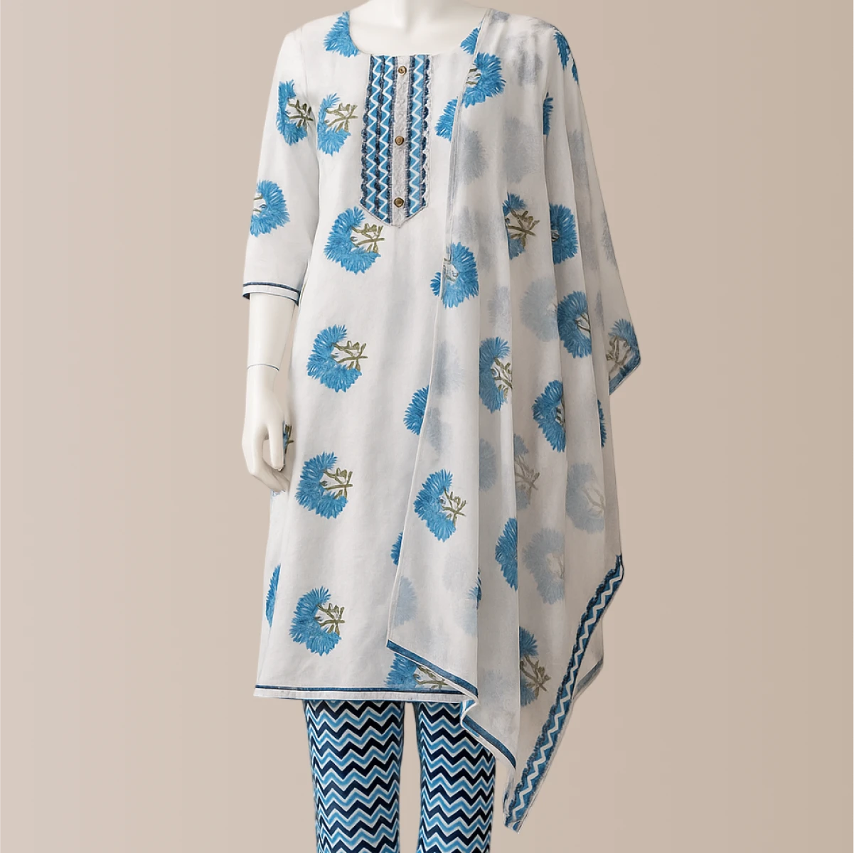 White outfit with blue floral patterns on a beige background