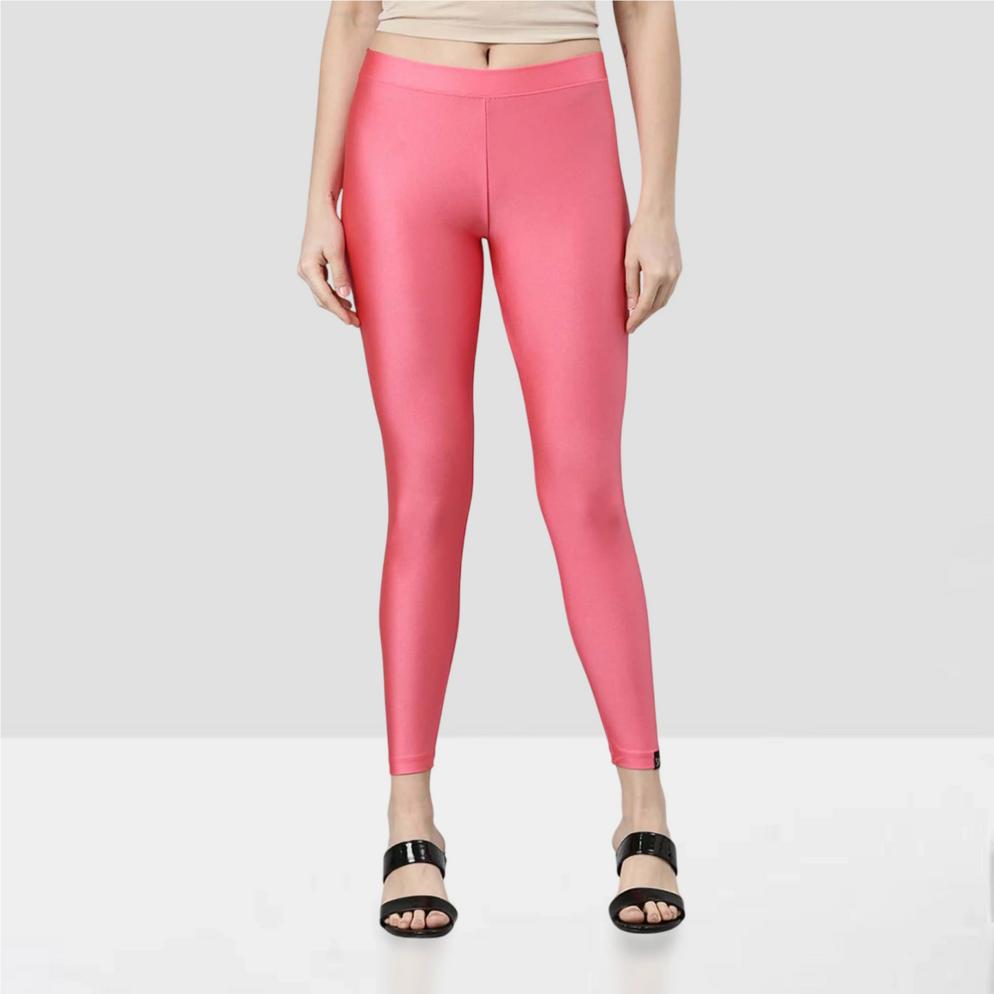 Person wearing bright pink leggings on a beige background