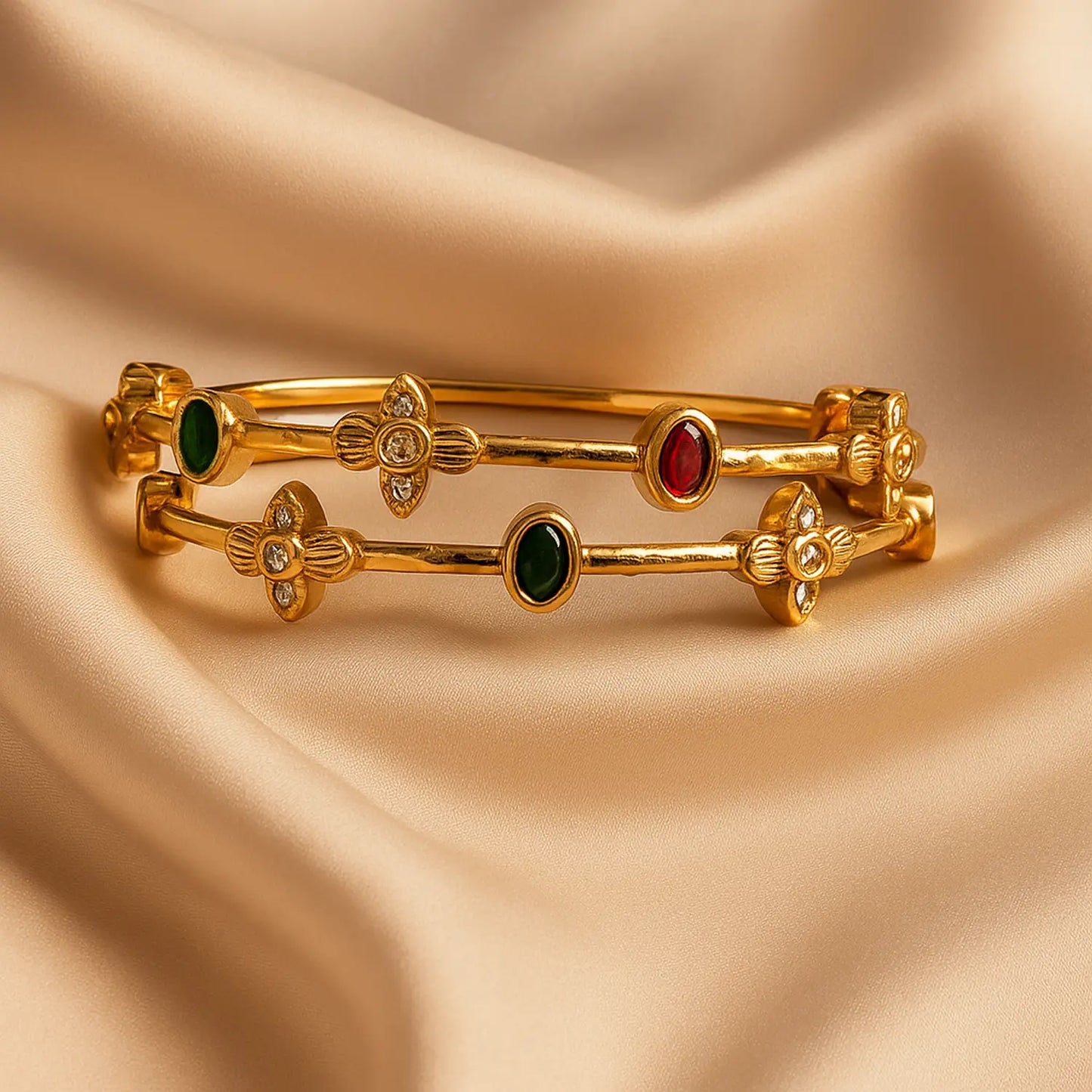 Gold bangles with gemstones on a beige fabric background