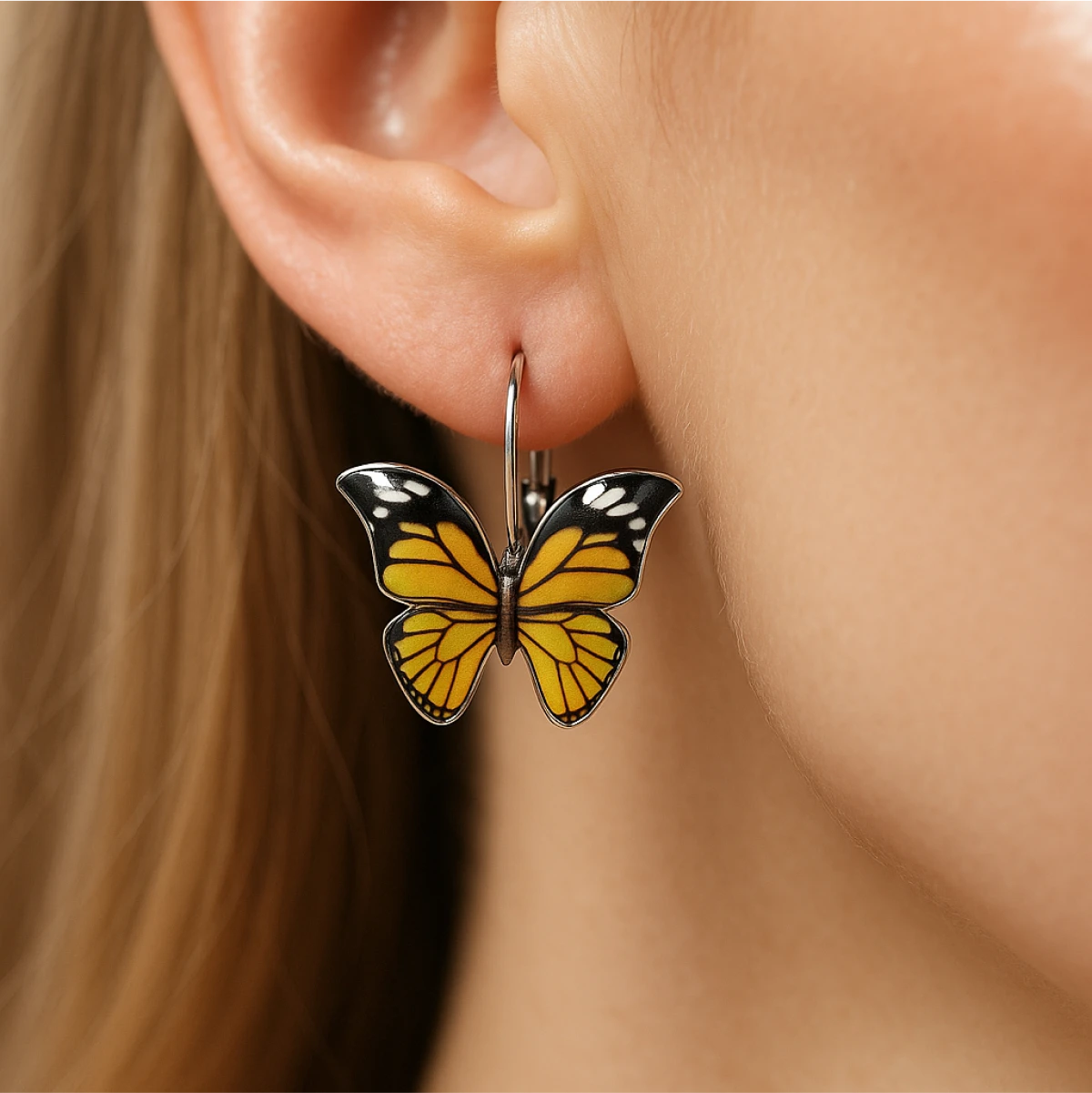 Butterfly-shaped earring worn on an ear with a blurred background