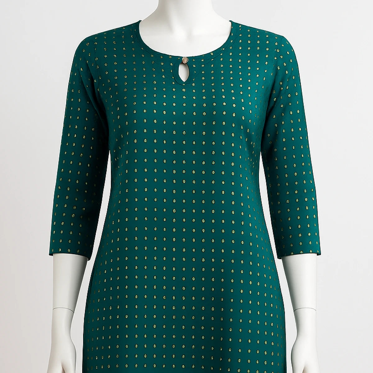 Green dress with gold polka dots on a mannequin against a white background