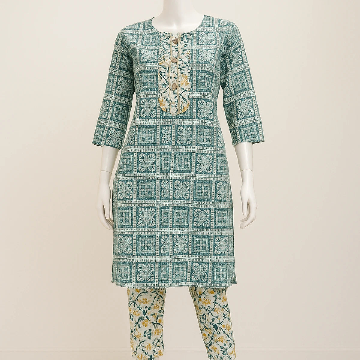 Green patterned kurta with matching pants on a mannequin against a beige background