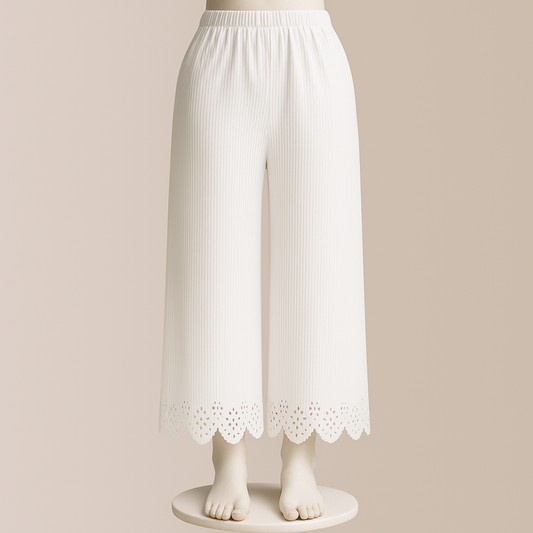 White ribbed pants with lace trim on a mannequin against a beige background