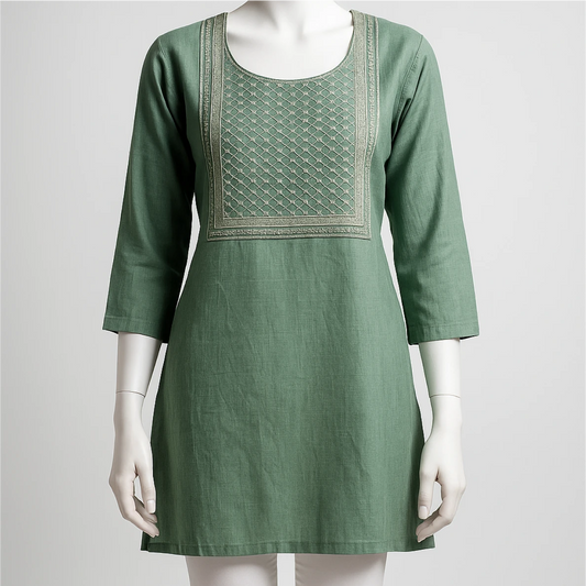 Green dress with embroidery on a mannequin against a white background