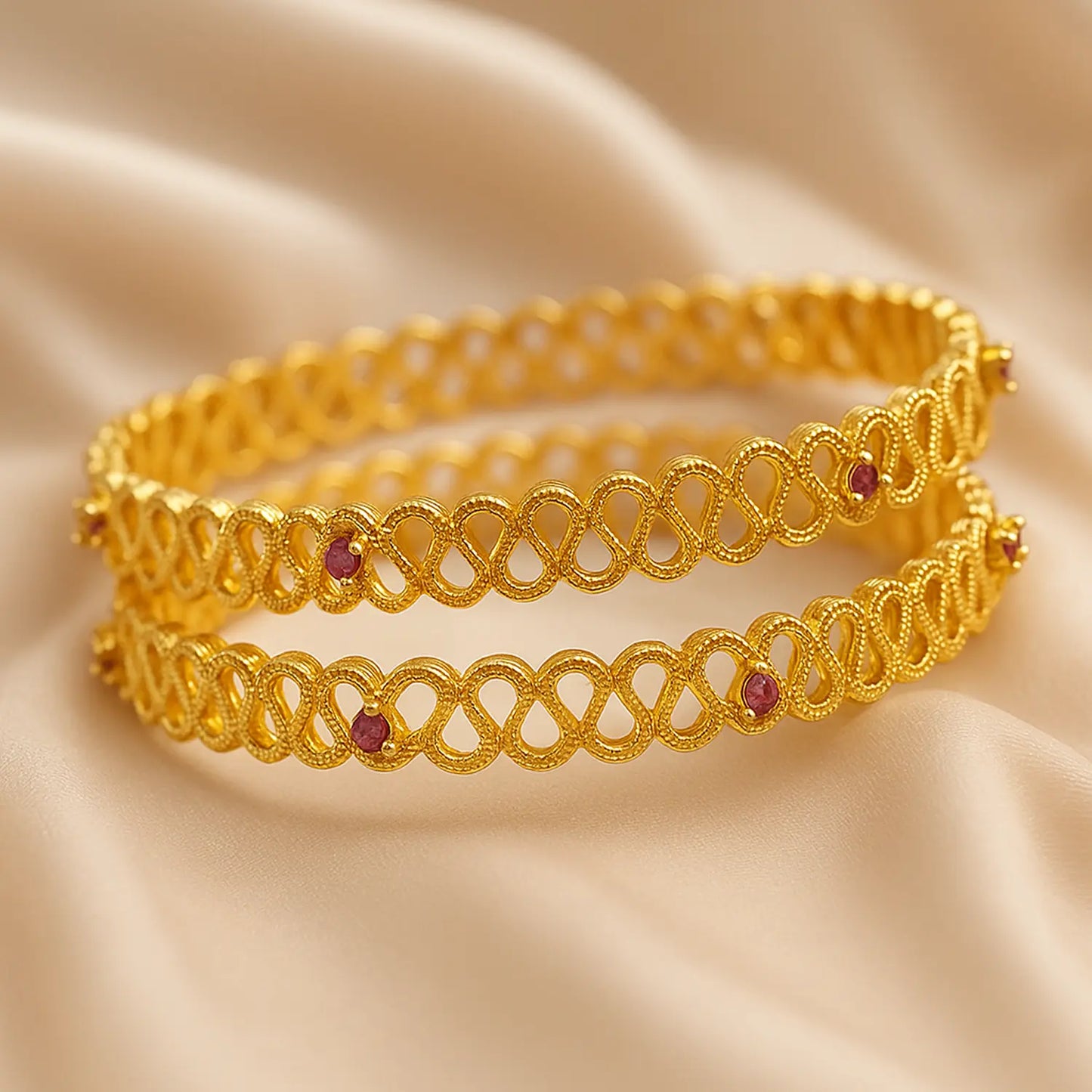 Gold bracelet with red stones on a beige fabric background