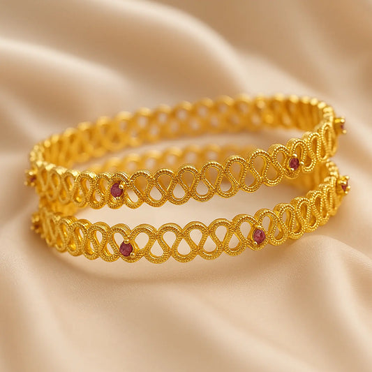 Gold bracelet with red stones on a beige fabric background