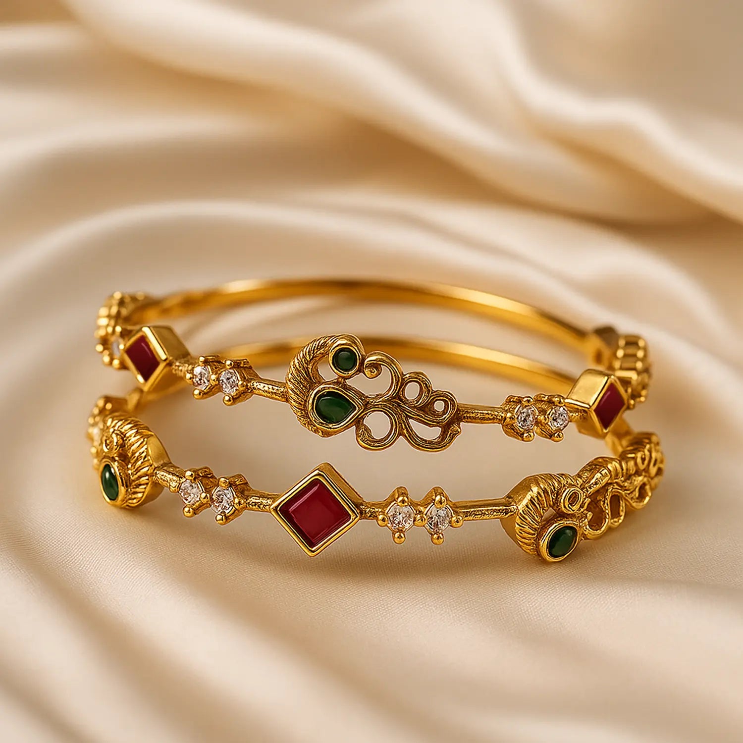 Gold bracelets with gemstones on a beige fabric background