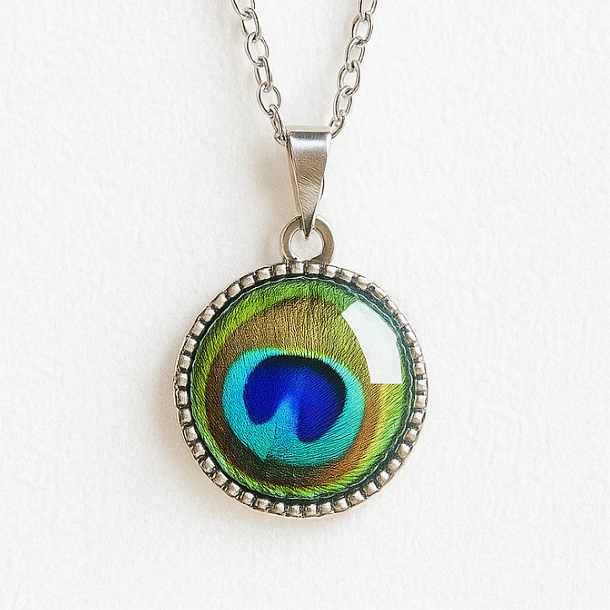 Peacock feather pendant necklace on a white background