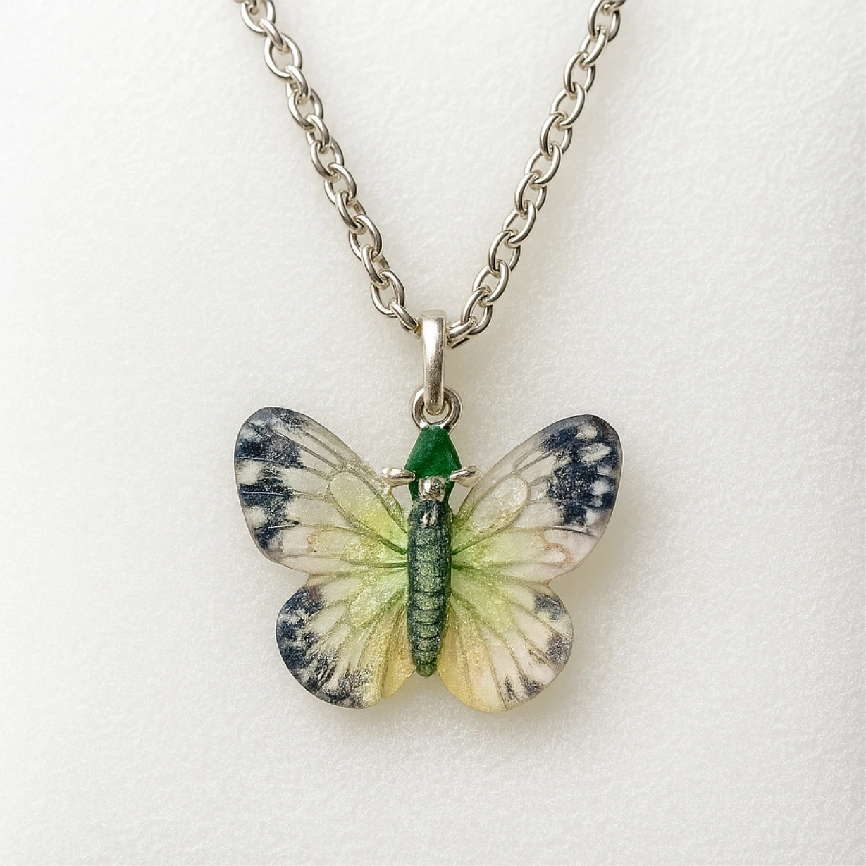 Butterfly-shaped pendant on a chain against a white background