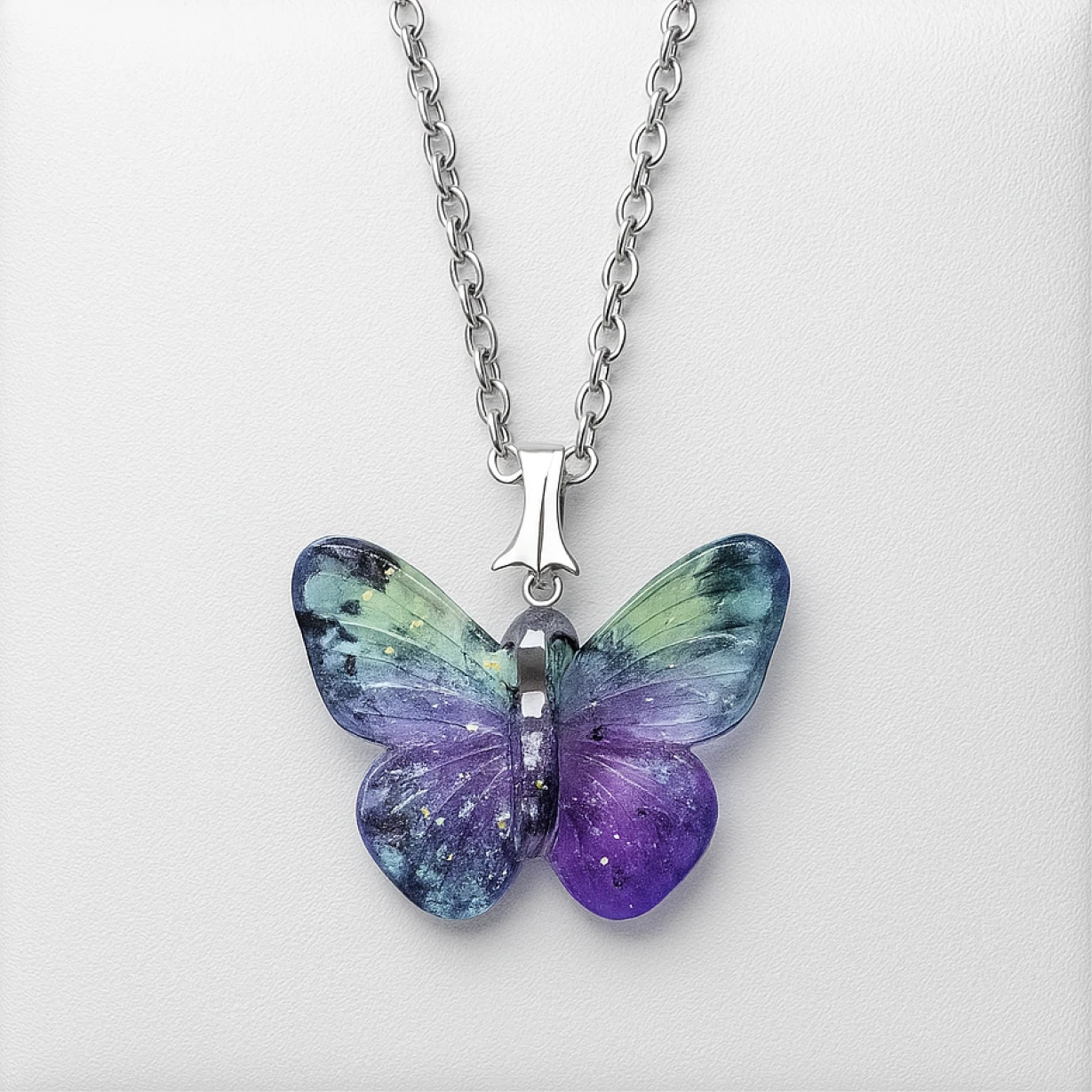 Butterfly-shaped pendant on a chain against a white background