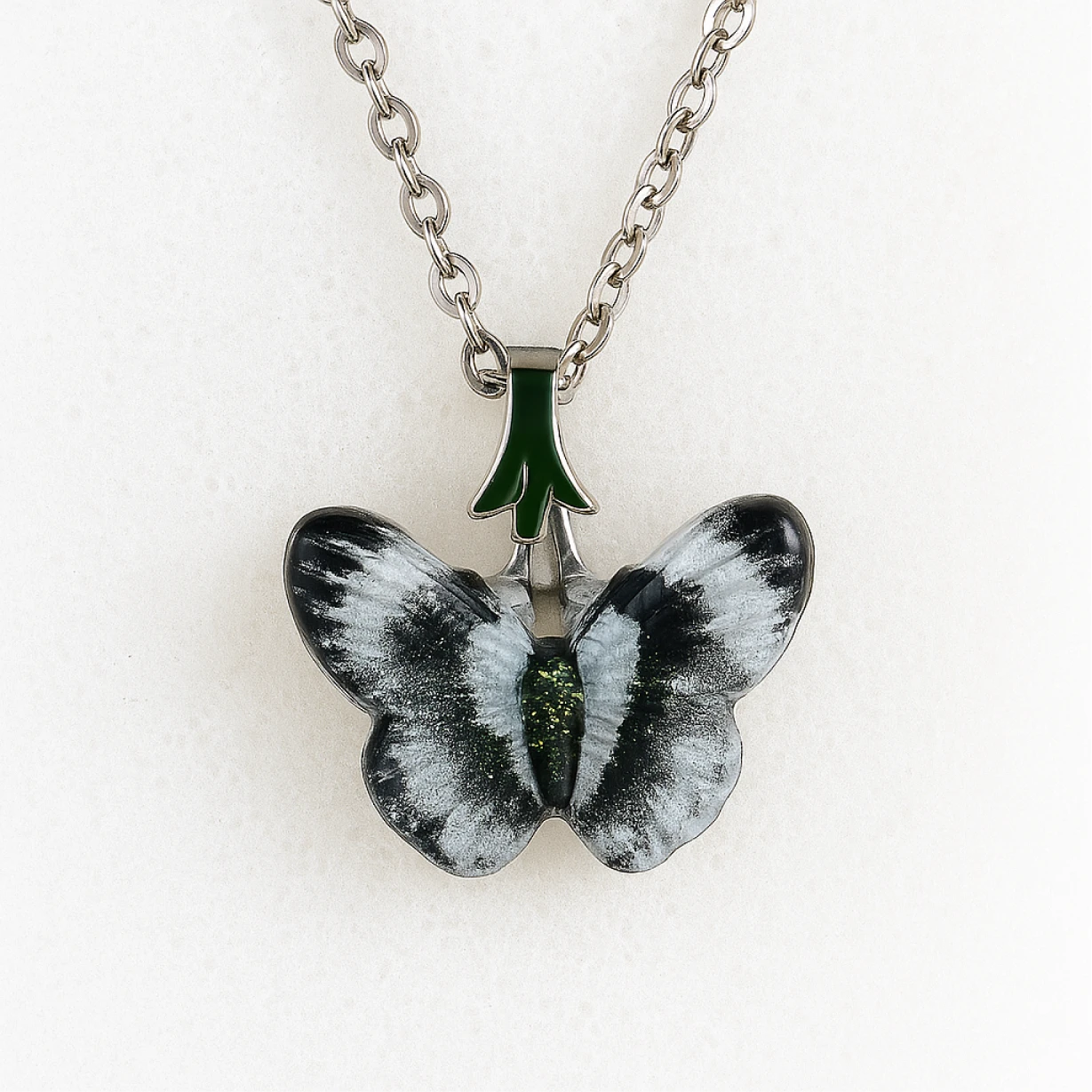 Butterfly-shaped pendant on a chain against a white background