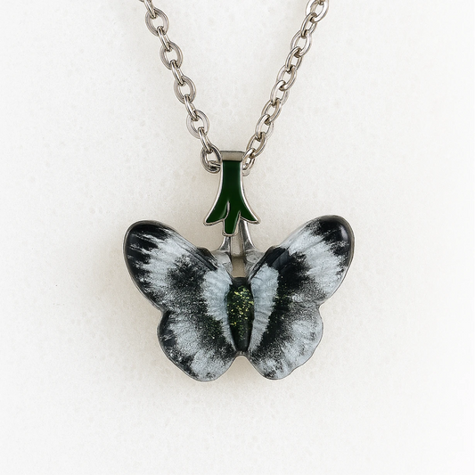 Butterfly-shaped pendant on a chain against a white background