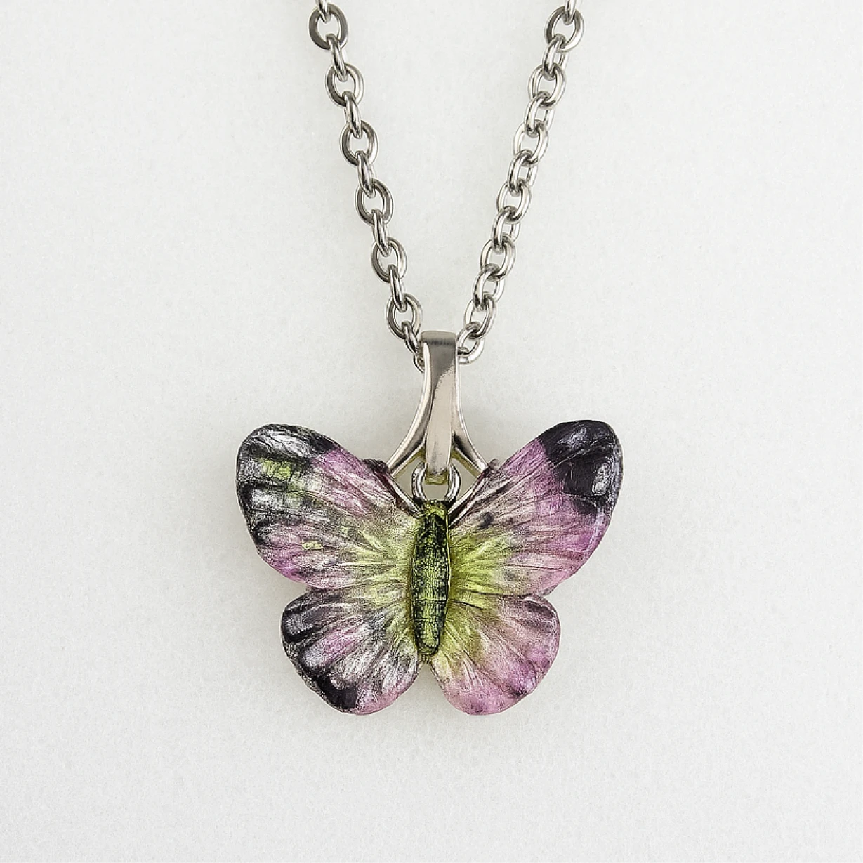 Butterfly-shaped pendant on a chain against a white background