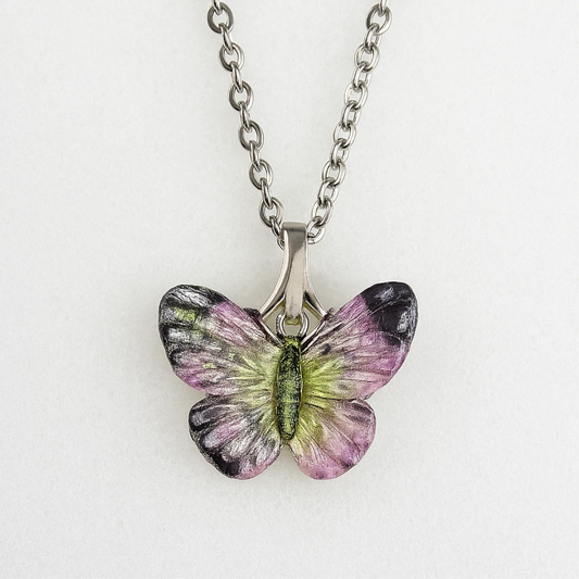 Butterfly-shaped pendant on a chain against a white background