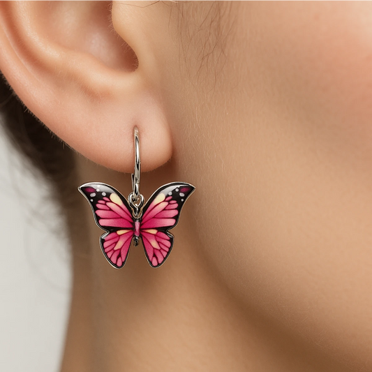 Pink butterfly earring worn on an ear with a neutral background