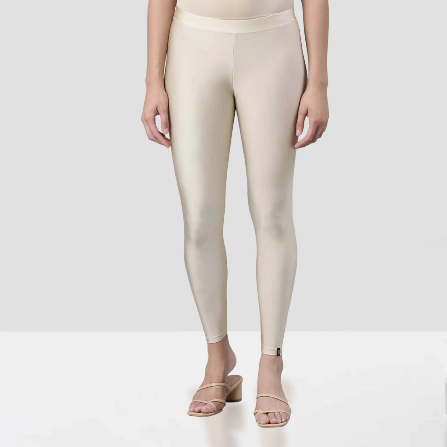 Beige leggings worn by a person on a white background