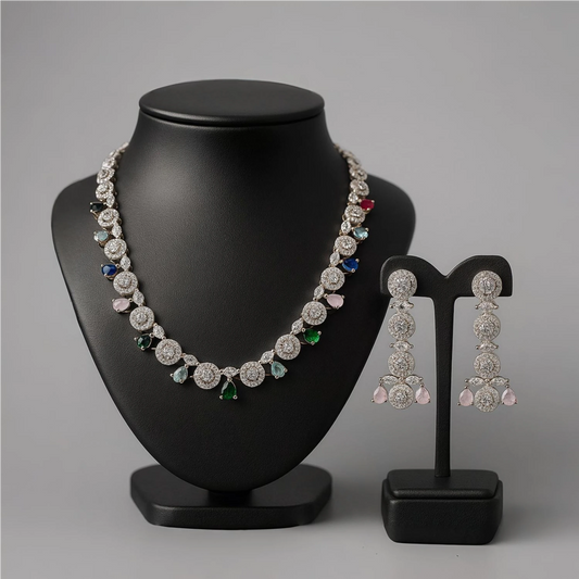 Jewelry set with necklace and earrings on black stands against a gray background