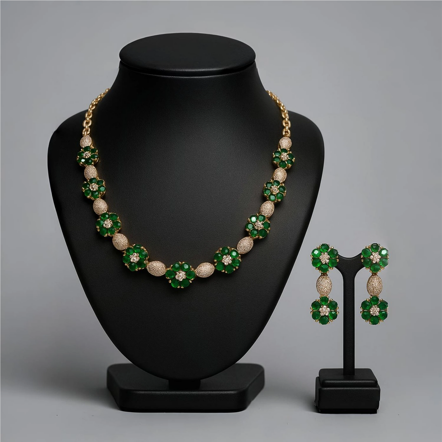 Jewelry set with necklace and earrings on black stands against a gray background