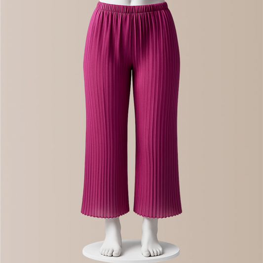 Pink pleated pants on a mannequin against a beige background