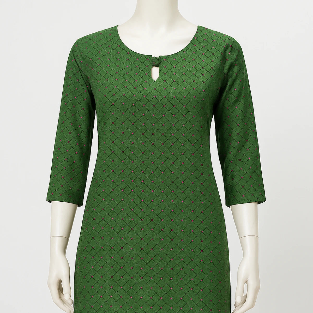 Green patterned dress on a mannequin against a white background